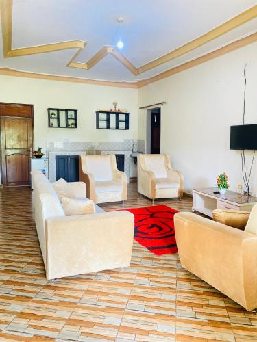 a living room with white couches and a red rug at Jseason Faith-based retreat resort in Kagolomolo