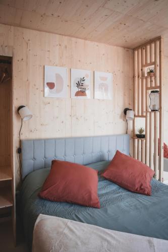 a bedroom with a blue bed with two red pillows at Le Studio du Hameau in Sales