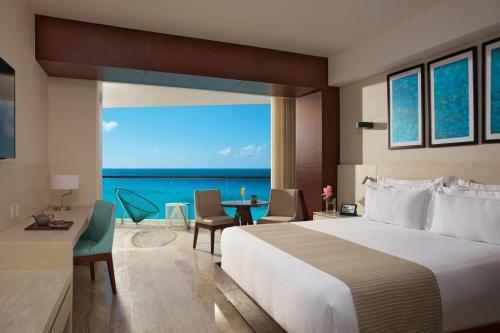 a bedroom with a bed and a view of the ocean at Krystal Grand Cancun All Inclusive in Cancún