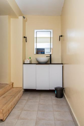 a bathroom with a sink and a window at Stixx By The Mountain in Nanyuki