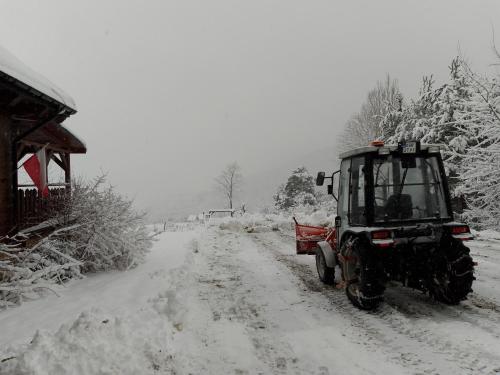 a tractor is driving down a snow covered road at ORLIK - pokoje gościnne in Uście Gorlickie