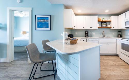 une cuisine avec des armoires blanches et une table et des chaises dans l'établissement Phoenix X 711 condo, à Orange Beach