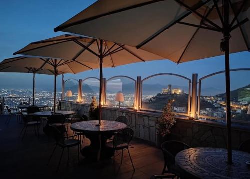 a restaurant with tables and umbrellas on a balcony at Pantarei Palace in Lettere