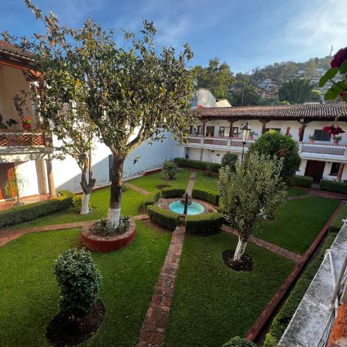 a garden with trees and a fountain in the middle at Hotel Calli Yoloiztac, Valle de bravo in Valle de Bravo