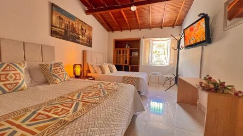 a bedroom with two beds and a living room at Casa La Morada in Medellín