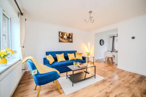 a living room with a blue couch and a table at Fowler House 2 Bedroom ,Free WIFI, Parking, Crawley, Close to Gatwick Airport, Contractor friendly, business travellers in Three Bridges