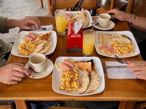 uma mesa de madeira com pratos de comidas e bebidas para o café da manhã em Hotel Beijing Cartagena em Cartagena de Indias