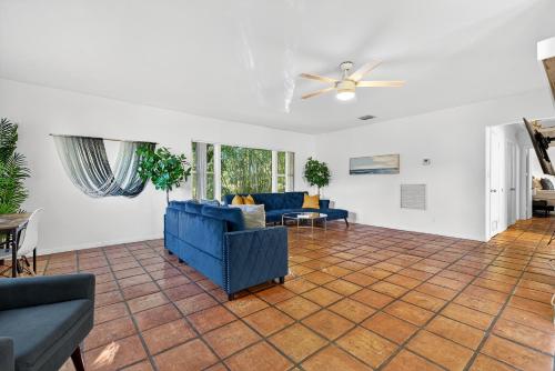 a living room with blue furniture and a ceiling fan at Sunny 2-Bedroom Miami Retreat with a Bright, Spacious Living Area & Relaxing Outdoor Seating in Fort Lauderdale
