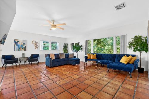a living room with blue couches and chairs at Sunny 2-Bedroom Miami Retreat with a Bright, Spacious Living Area & Relaxing Outdoor Seating in Fort Lauderdale