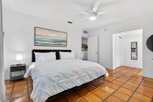 a white bedroom with a bed and a ceiling fan at Sunny 2-Bedroom Miami Retreat with a Bright, Spacious Living Area & Relaxing Outdoor Seating in Fort Lauderdale