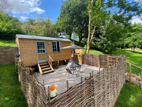 a tiny house in a garden with a fence at Heron Leap in Knaresborough
