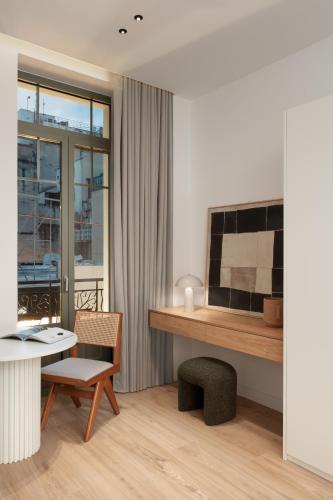 a living room with a desk and a table with a chair at Anfides Boutique Hotel in Patra