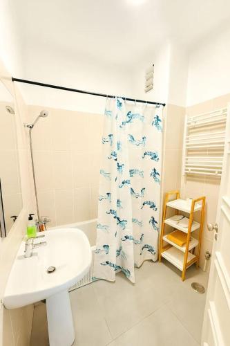 Un baño con lavabo y cortina de ducha. en Cascais Ocean Apartment, en Cascais