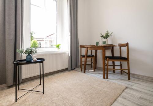 ein Esszimmer mit Tisch und Stühlen und einem Fenster in der Unterkunft Nowoczesne Studio Mała Andrzeja, Kawalerka Inowrocław, Modern Studio, kamienica in Inowrocław