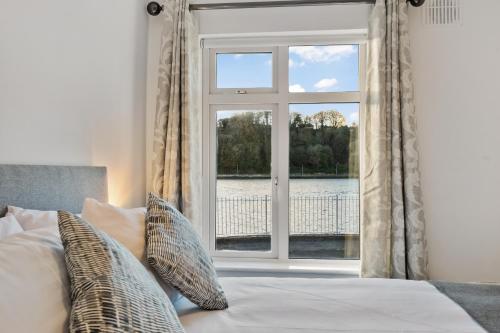 um quarto com uma janela e uma cama com almofadas em 2 Rushbrooke Hotel Apartments Cobh County Cork em Cobh