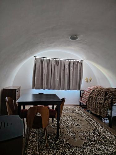 a room with a table and a bed and a window at Tichá chalupa in Liptovský Hrádok