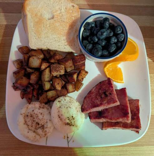 a plate of breakfast food with eggs potatoes and toast at Applewood Inn Bed and Breakfast in Twillingate