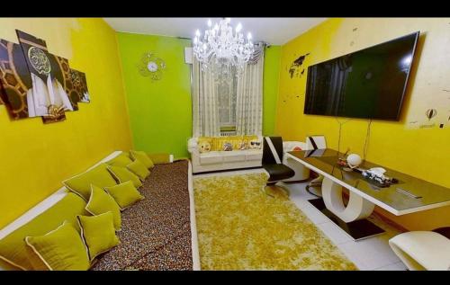 a living room with yellow walls and a large television at private room in Seveso