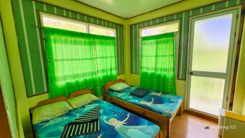 una habitación con dos camas en una habitación con ventanas en Sagada Staycation near Sea of Clouds View, en Sagada