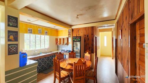 Una cocina y un comedor con mesa y sillas de madera. en Sagada Staycation near Sea of Clouds View, en Sagada