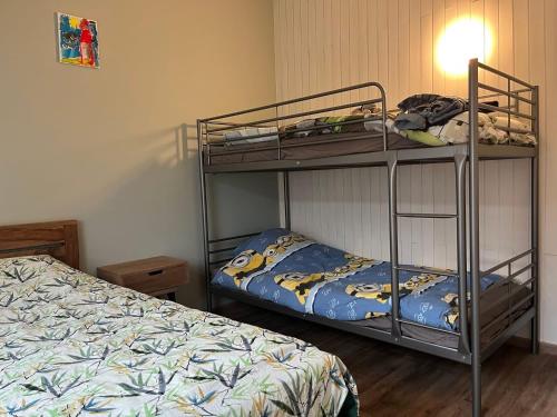 Un dormitorio con dos literas y una cama. en Chez Fernand, en Hotton