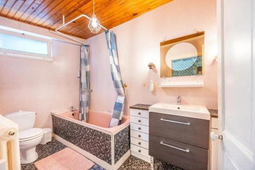 a bathroom with a toilet and a tub and a sink at Chambre Nuit d'Asie in Montournais