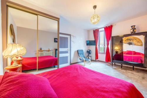 a bedroom with two beds and a large mirror at Chambre Nuit d'Asie in Montournais