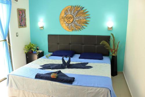 1 dormitorio con 1 cama con pared azul en Maya Vacanze Playa Quinta B&B, en Playa del Carmen