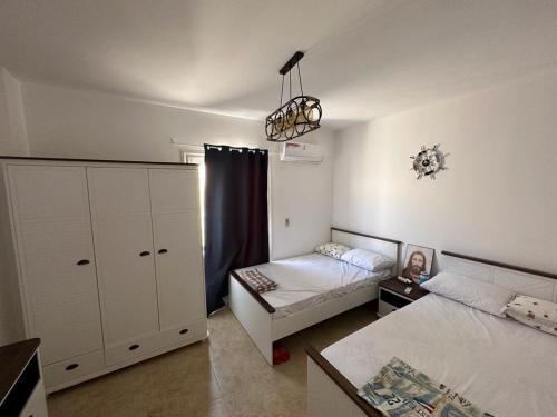 a bedroom with two beds and a dresser at Modern Front Seaview chalet El Sokhna in Ain Sokhna