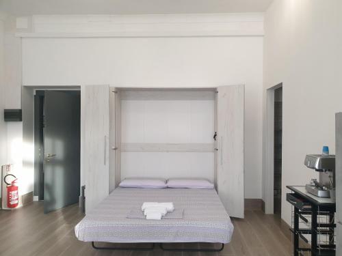 a bed in a room with a white wall at Da zia Fabri in Gorizia
