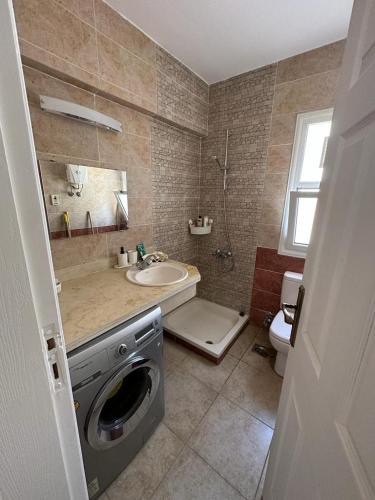 a bathroom with a sink and a washing machine at Modern Front Seaview chalet El Sokhna in Ain Sokhna