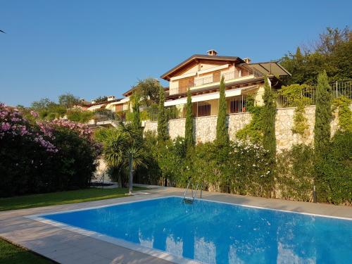 una piscina di fronte a una casa di Il Paradiso Apartments Great View Gardasee a Torri del Benaco