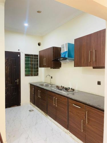 una cucina con mobili in legno e un lavello di Luxury & Cozy Villa In the Heart of Bahria Town a Karachi