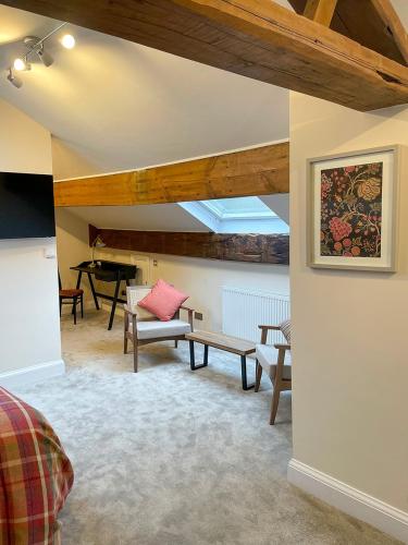 a living room with a bench and a piano at Westwood Boutique Aparthotel by Birch Stays in Glossop