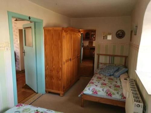 une chambre avec un lit et une armoire en bois dans l'établissement Familienfreundliche Gemütliche Ferienwohnung In Luchau Mit Garten Und Grill -, à Glashütte