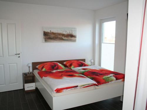 a bedroom with a bed with red pillows and a window at Villa Kiek Ut in Trent