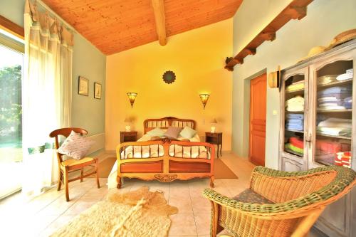 a bedroom with a bed and chairs in a room at Gite Four De Mon Père in Salignac Eyvigues
