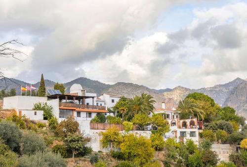 eine Gruppe von Häusern auf einem Hügel mit Bergen in der Unterkunft Ferienhaus für 4 Personen und 2 Kinder in Durcal, Andalusien Provinz Granada in Dúrcal