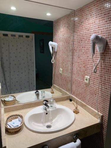 a bathroom with a sink and a mirror at Hotel El Atalaya in Fuentidueña de Tajo