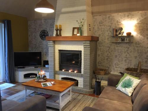 ein Wohnzimmer mit Kamin und Tisch in der Unterkunft Ferienhaus für 5 Personen ca 100 m in De Panne, Flandern Plopsaland und Umgebung in De Panne