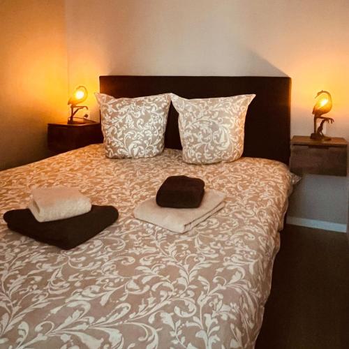 a bed with two hats and pillows on it at 't Haasnestje in Harderwijk