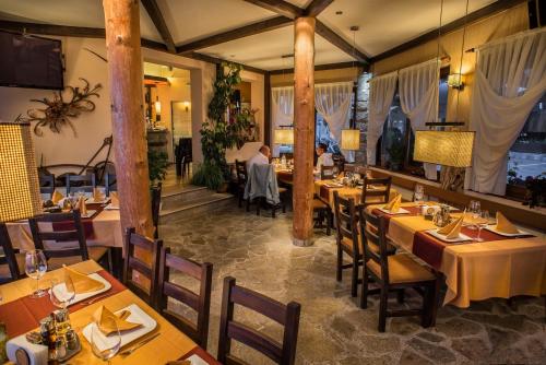 a restaurant with tables and chairs in a room at Family Hotel Eterno in Tsigov Chark