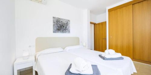 una camera da letto con un letto bianco con asciugamani sopra di Son Ropit a Calas de Mallorca