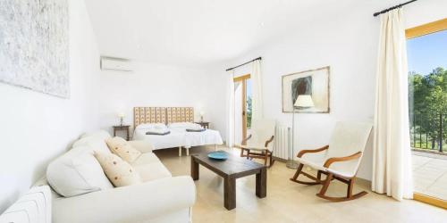 un soggiorno bianco con divano bianco e tavolo di Son Ropit a Calas de Mallorca
