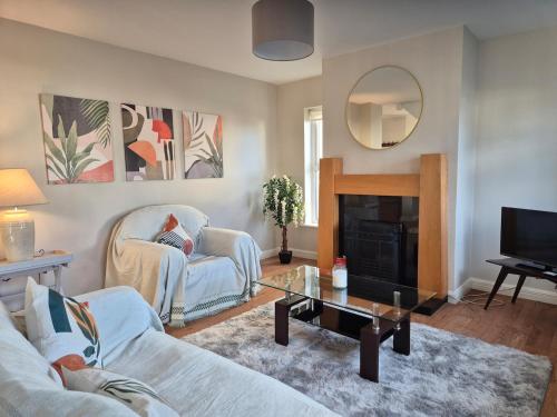 a living room with a couch and a fireplace at Beautiful Spacious 4-Bedroom House in Louisburgh in Louisburgh