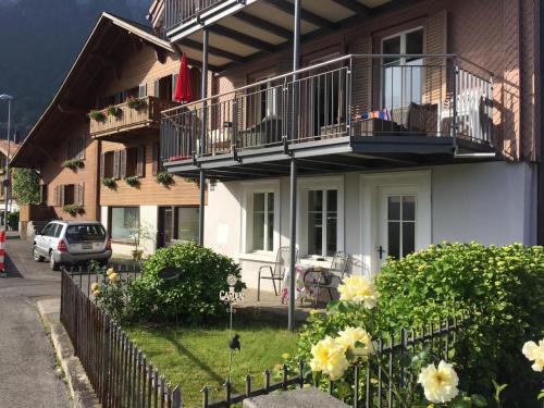 Una casa con balcones y flores delante de ella. en Haus Am See, en Därligen