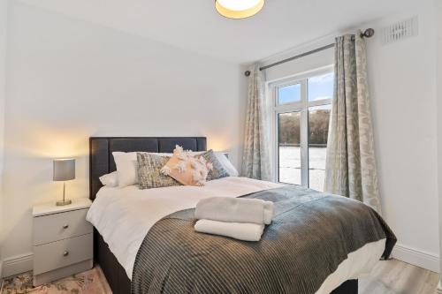 um quarto com uma cama grande com janela em 5 Rushbrooke Hotel Apartments Cobh County Cork em Cobh