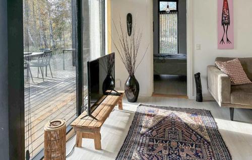 un salon avec cheminée et fauteuil et une véranda dans l'établissement Five-Bedroom Holiday Home In Rorvig, à Rørvig