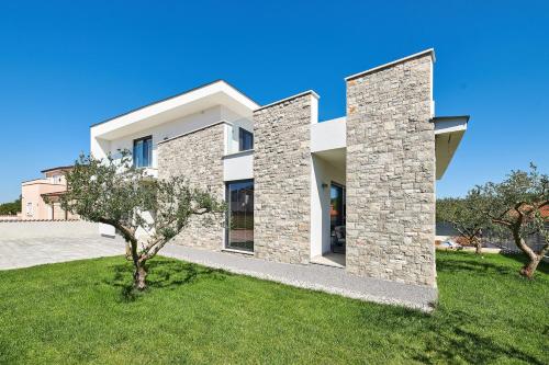 une maison moderne avec une façade en pierre dans l'établissement Villa Dolcea Elegant Und Stilvoll Mit Pool, à Kaštel