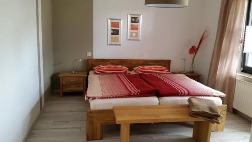 ein Schlafzimmer mit einem Bett mit roten Kissen darauf in der Unterkunft Ferienwohnung Himmelreich in Antfeld